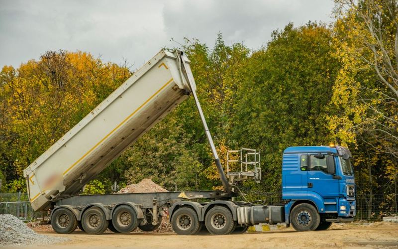Tipper lorry unloading aggregate on a construction site, for muck away and deliveries (illustrative stock photo)
