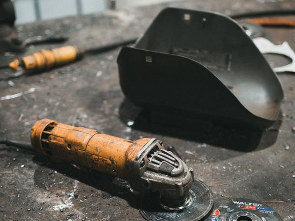 Angle grinder and cutting discs on a workbench (illustrative stock photo)
