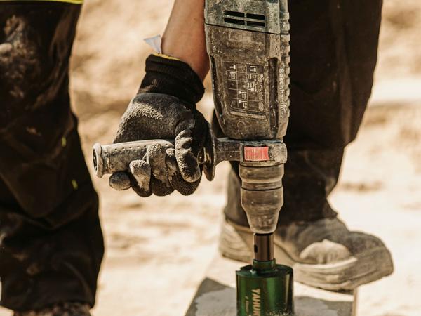 Electric breaker (demolition hammer) breaking concrete (illustrative stock photo)