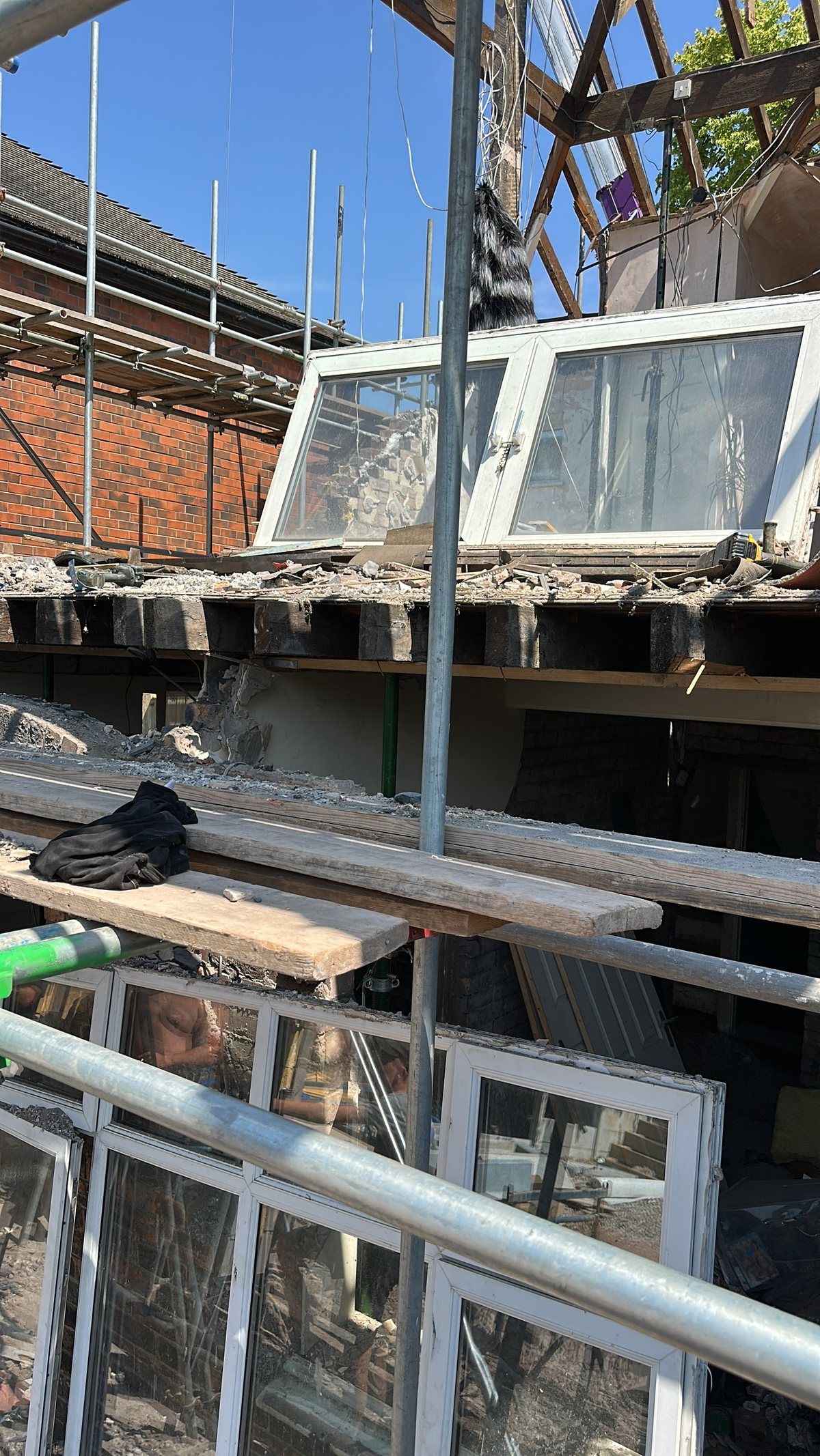 House extension under construction with new roof timbers, windows and scaffold access