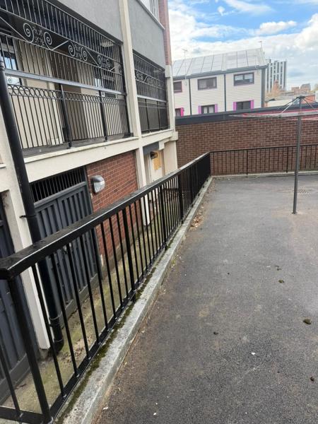 Resurfaced tarmac access ramp with refurbished railings