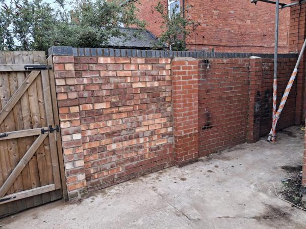 Rebuilt brick boundary wall with timber gate