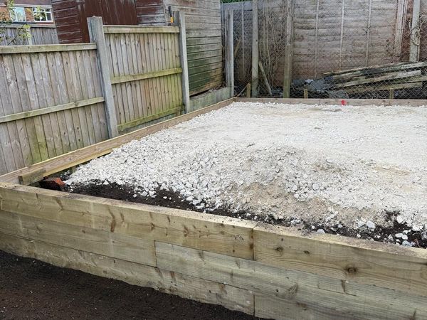 Timber-edged gravel base prepared for a garden building