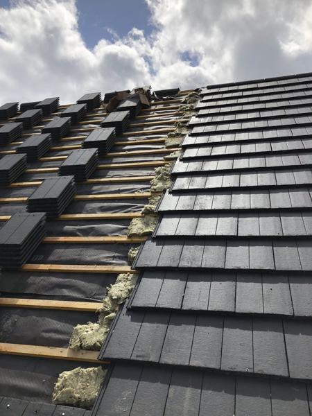 Interlocking concrete tiles being laid on a new-build roof