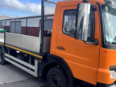 Orange Mercedes flatbed lorry, side view